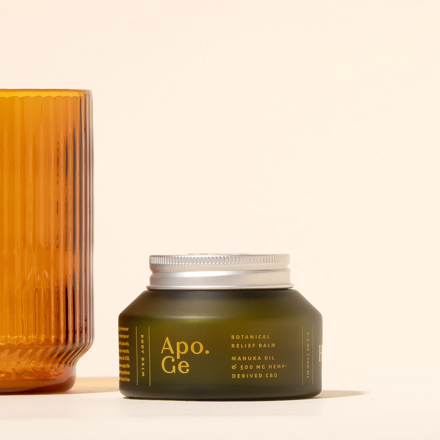 100 ml Green jar of Apo.Ge botanical relief balm with a silver lid on a light background