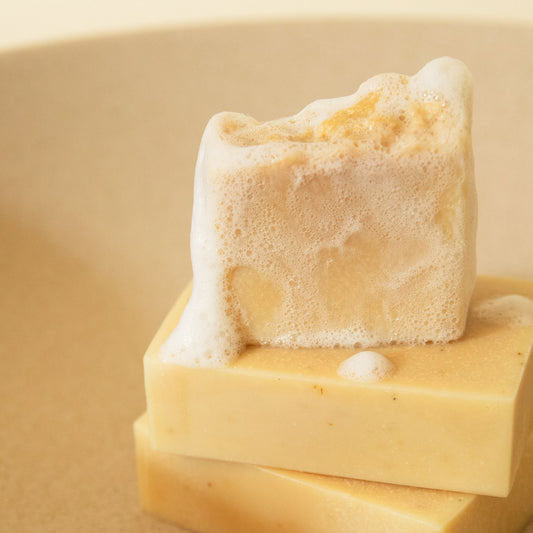 Stack of Apo.Ge sensitive skin bar soap with suds