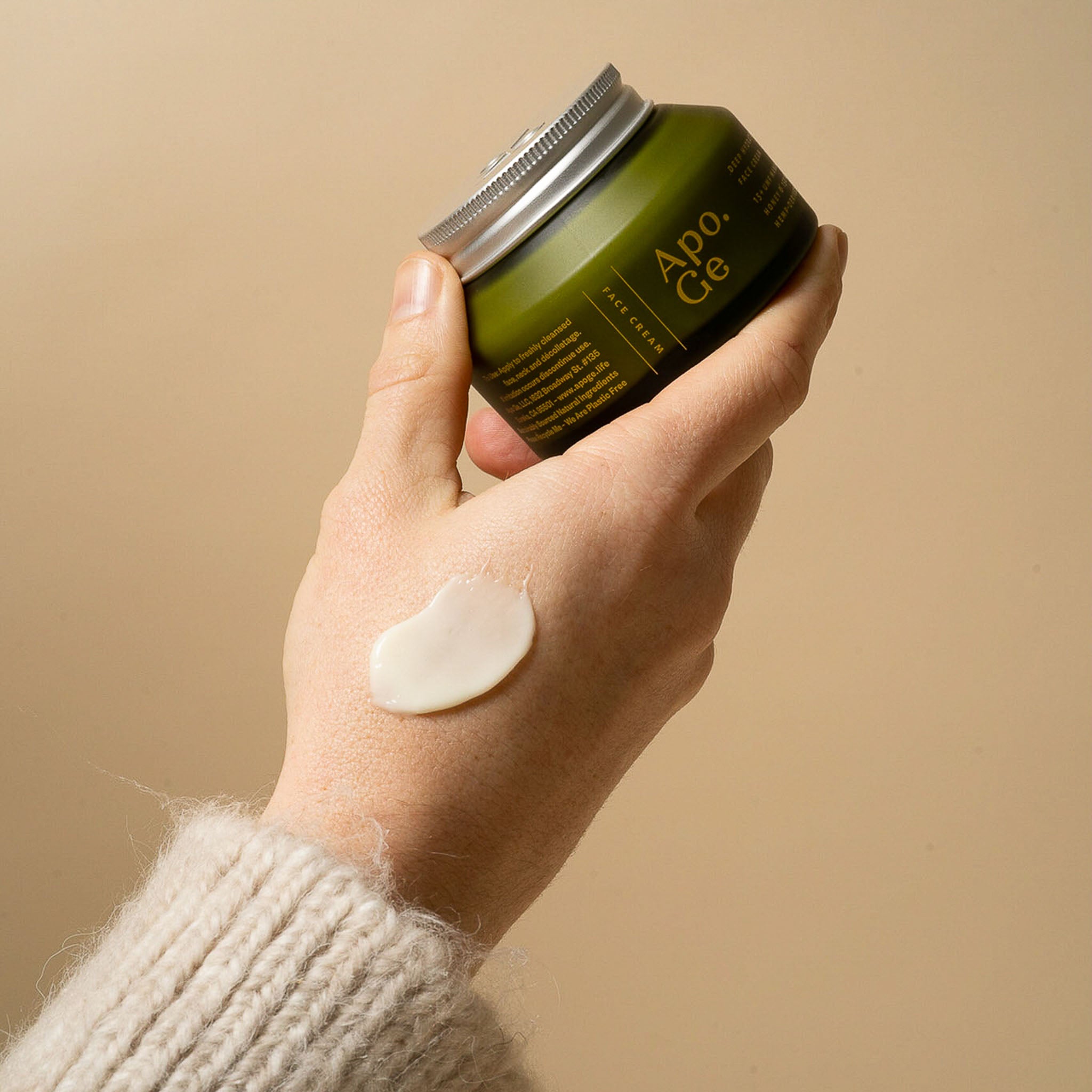 Hand holding Apo.Ge mānuka honey skincare deep hydration face cream.