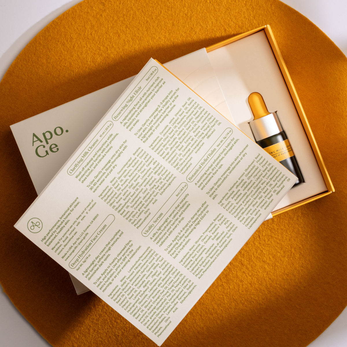 Apo.Ge skincare product with dropper and leaflet on a gold surface