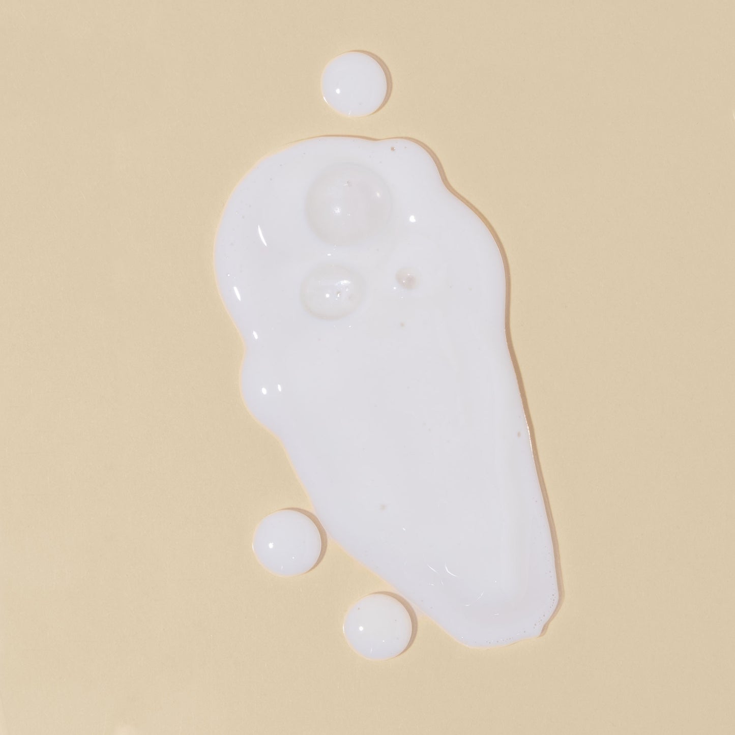 apo ge manuka honey skincare clarifying milk cleanse droplets and smears on a beige background