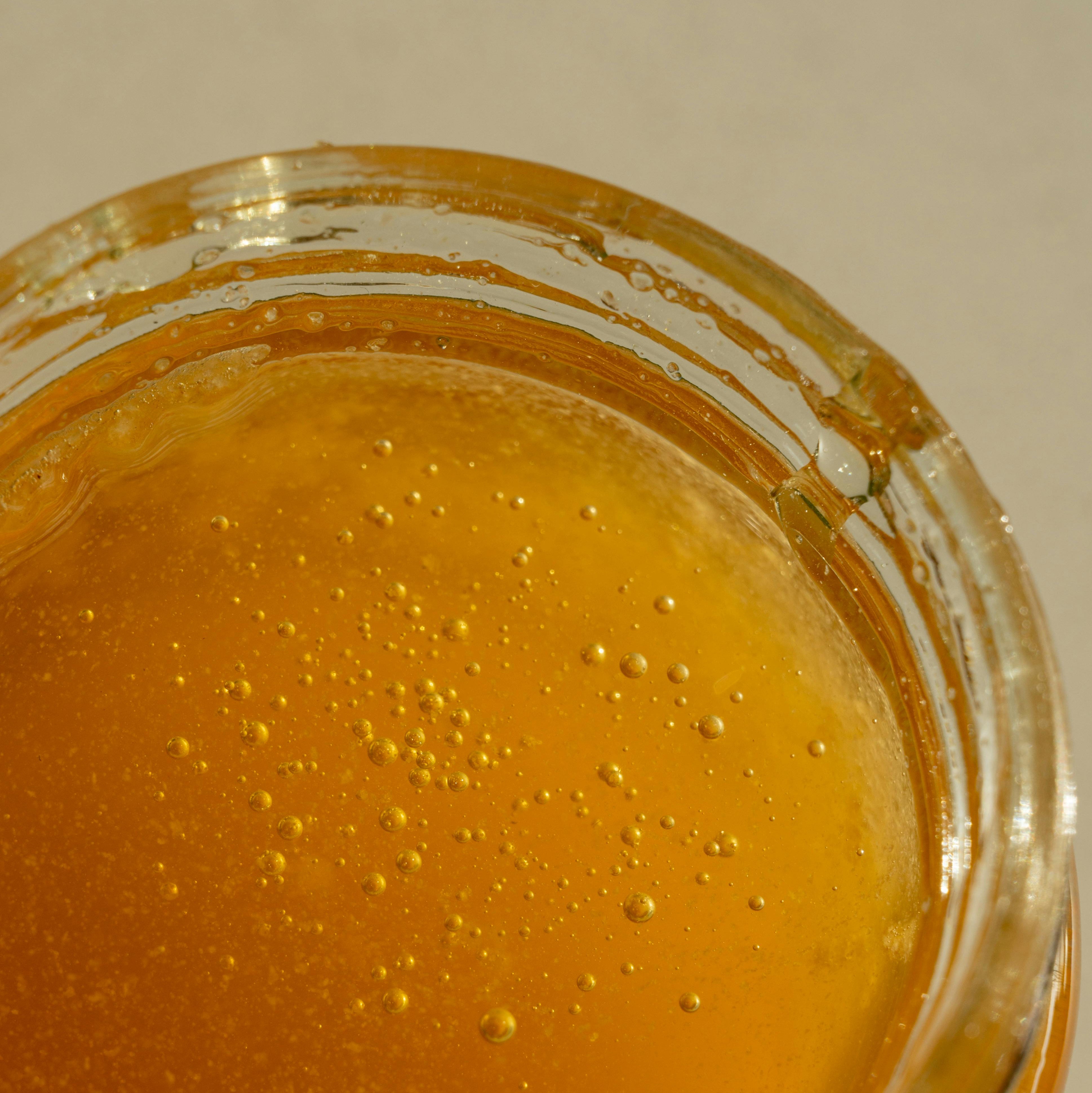 Close-up of a jar with mānuka honey on a plain background